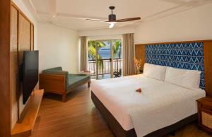 克罗托格奥瑞格斐济海滩度假酒店的一间卧室配有一张床、一台电视和一个阳台