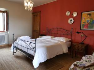 渥尔特拉Podere Campiano的一间卧室设有一张带红色墙壁的大床