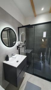 鲁特罗Willa Lawenda- Przytulny Domek的浴室配有盥洗盆和带镜子的淋浴
