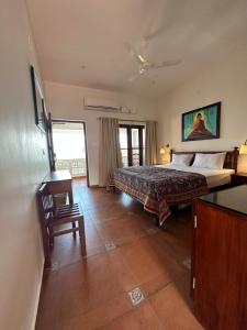 可瓦兰Buddha Beach Hotel的卧室配有1张床、1张桌子和1把椅子