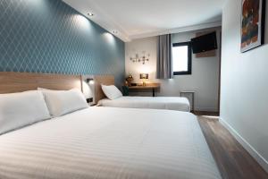 萨兰KYRIAD DIRECT ORLEANS NORD - Cap Saran的酒店客房设有两张床和一张桌子。