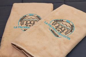 洛索亚河畔加尔甘蒂利亚Posada Rural SPA Granja LA TEJERA de Lozoya的棕色餐巾边的两块贴纸