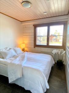 耶姆赛Himos Mökki superior - Chalet Cottage superior ski-in-ski-out的卧室配有一张大白色床和窗户
