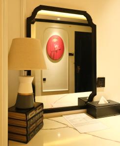 胡志明市Nicecy Boutique Hotel的一间卧室配有镜子和梳妆台上的灯
