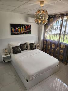 马罗尼河畔圣洛朗Hello-Guyane, Marina 5, Studio Prestige 5 étoiles的卧室配有白色的床和吊灯。