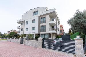 安塔利亚Rose Residence - Trendy Apartments Near The Beach的前面有栅栏的白色建筑