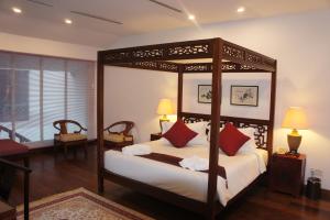 马六甲希伦棕榈套房酒店的一间卧室配有一张带红色枕头的天蓬床