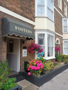 韦茅斯Fosters Guest House的建筑前方有鲜花的商店