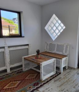 克利默内什蒂Casa Albinuța的一间设有两张长椅、一张桌子和一个窗户的房间