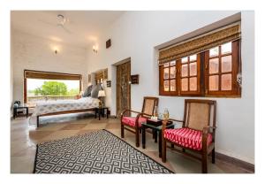 奥拉奇哈Chandera Kothi的一间卧室配有一张床、两把椅子和一张桌子