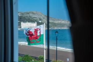 兰迪德诺Promenâd Bed & Breakfast的从带国旗的窗户欣赏海滩美景