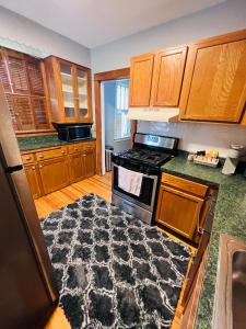 Richmond HeightsDale first floor的厨房配有木制橱柜和黑色地毯。