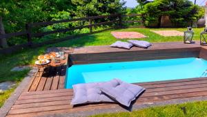 Anilio PelionGolden Mountain的一个带木甲板和桌椅的游泳池