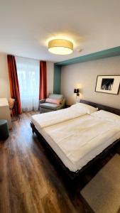 卢加诺裴斯泰洛卢加诺酒店的一间卧室配有一张大床和一张沙发