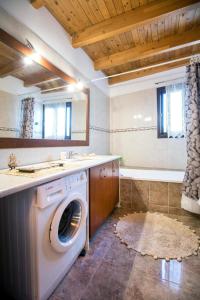 科斯基努拉斐拉度假屋的浴室配有洗衣机、水槽和浴缸