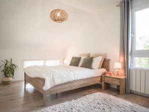 Nâves-ParmelanVenez Chez Vous - Le Cocon du Parmelan的白色的卧室设有一张大床和一个窗户