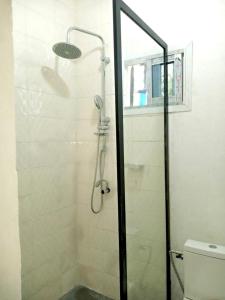 杜阿拉Gêna house的浴室里设有玻璃门淋浴