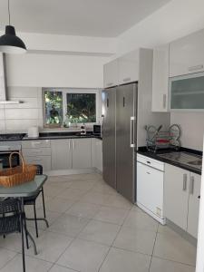 MalhãoMonte Papa Figos的厨房配有白色橱柜和不锈钢冰箱