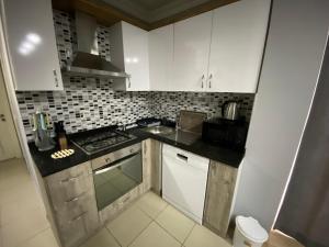 安塔利亚Tas Suites的厨房配有白色橱柜和炉灶烤箱。