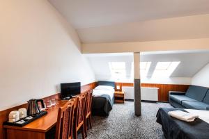布拉格哲拉塔瓦哈酒店的客房设有一张床、一张书桌和电视