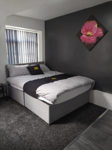 布莱克浦Black Ocean Holiday Apartments的卧室配有一张挂着鲜花的床