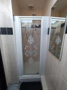 布莱克浦Black Ocean Holiday Apartments的浴室里设有玻璃门淋浴