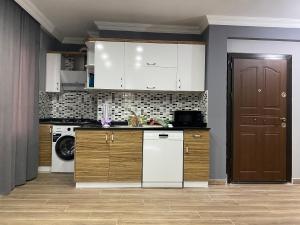 安塔利亚Tas Suites的厨房配有白色橱柜、洗衣机和烘干机
