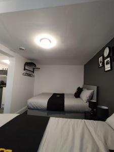 布莱克浦Black Ocean Holiday Apartments的一间卧室设有两张床,墙上挂着一个时钟。