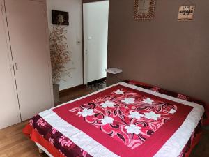 滨海博瓦Vaiana的一间卧室配有一张带红白毯子的床