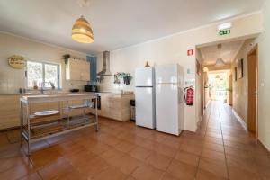 阿尔热祖尔Aljezur Villas的厨房配有白色冰箱,铺有瓷砖地板。