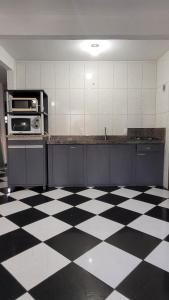 邦比尼亚斯Solar Alcantara & Lazzarotto (Residencial)的厨房铺有黑白的格子地板。