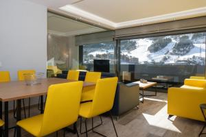 兰索尔THE MIRROR & SPA by Elegant Residences的一间带桌子和黄色椅子的用餐室