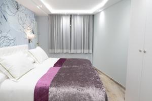 兰索尔THE MIRROR & SPA by Elegant Residences的一间卧室配有一张带紫色和白色毯子的床