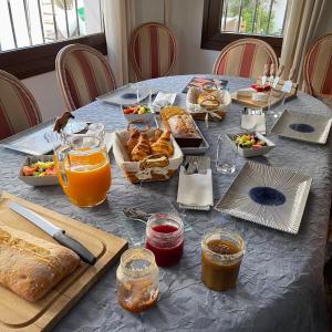 多列毛利诺斯Terra Aloé的一张蓝色桌子,上面有食物和橙汁,面包