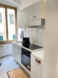 斯培西亚Paolina Home的厨房配有白色橱柜和炉灶烤箱。