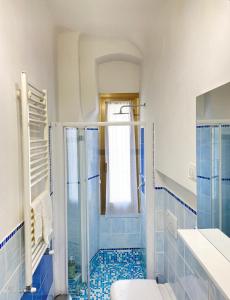 斯培西亚Paolina Home的带淋浴和卫生间的浴室以及蓝色瓷砖。
