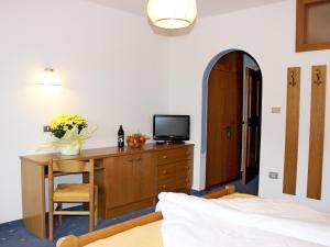 拉古多加尼安德莱特酒店的一间卧室配有一张桌子、一台电视和一张床