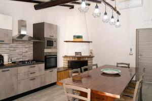 UcriaB&B Tenuta Piano Campo的一间带木桌的厨房和一间餐厅