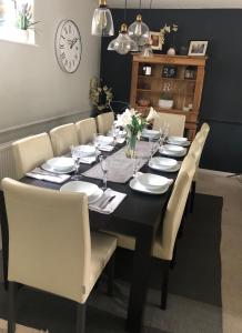 巴斯Holloway House的一张黑色餐桌,配有白色的盘子和椅子
