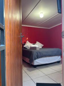 彼得马里茨堡Grey house lodge的一间卧室设有一张床和红色的墙壁