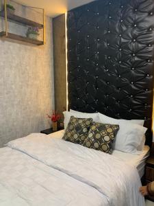 巴淡岛中心Batam Three Bedrooms Apartment - One Residence 2AG -的一间卧室配有一张大床和黑色床头板