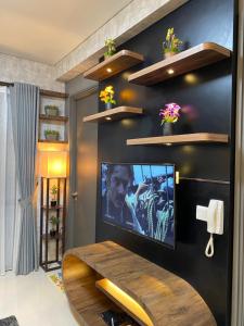 巴淡岛中心Batam Three Bedrooms Apartment - One Residence 2AG -的一间客厅,在黑色的墙上配有电视