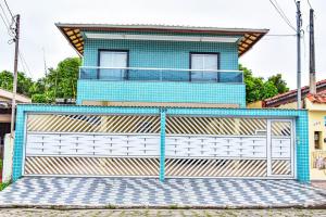 索莱马Casa com Wi-Fi a 400 metros da Praia Maracanã-SP的建筑前有门的蓝色房子