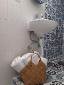 帕拉利亚卡泰里尼斯Olympian Chalet的一间带水槽、毛巾和篮子的浴室