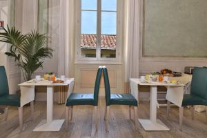 佛罗伦萨佛罗伦萨酒店的餐厅设有2张桌子和椅子以及窗户。