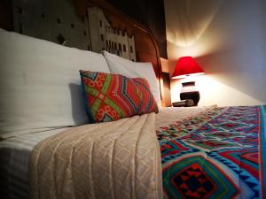 瓜纳华托Hotel Chocolate Tradicional的一间卧室配有一张带枕头和灯的床