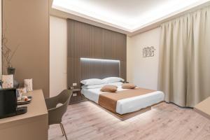 米兰Meneghina Suites Foresteria Lombarda的一间卧室配有一张床、一张书桌和一台电视
