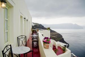 伊亚凯弗天使酒店的阳台配有桌椅,享有海景。