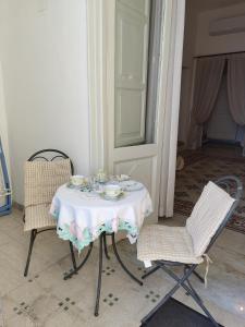 波西塔诺Casa La Bionda的一张桌子、两把椅子和一张桌子及一张白色的桌布