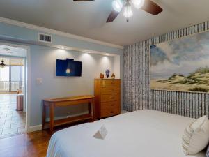 帕德雷岛MP217 Gulf view condo with Boardwalk to Beach的一间卧室配有一张床、一个梳妆台和电视。